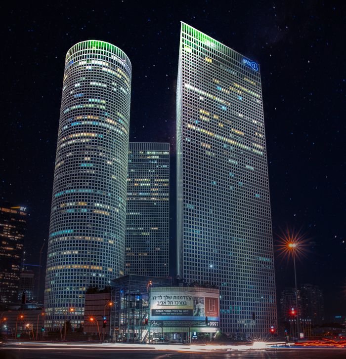 Stunning nighttime view of iconic skyscrapers in Tel Aviv under starry sky.